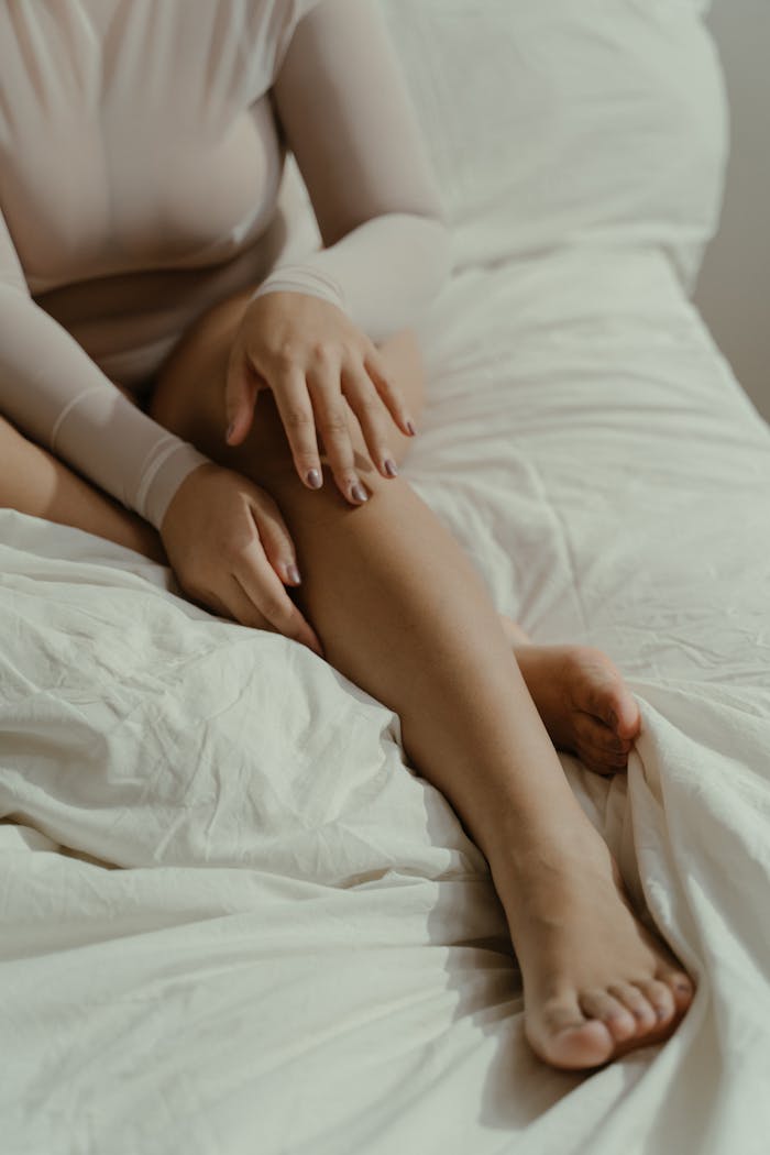 Crafting Captivating Headlines: Your awesome post title goes here Close-up of a woman sitting in a bodysuit on a bed, capturing a serene and intimate moment.